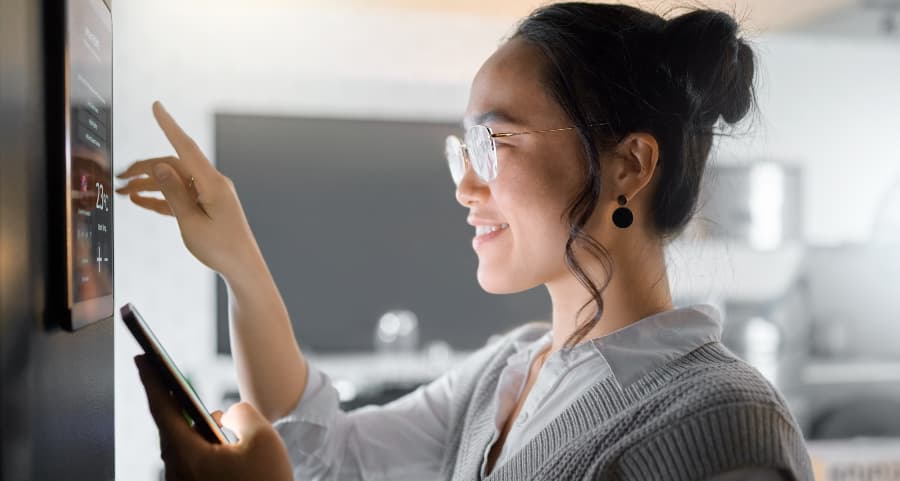 Woman using touch screen to interact with smart home